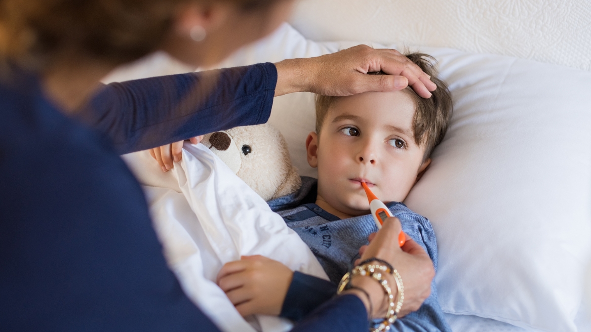 A sick child with a thermometer showing symptoms of Yellow Fever, appearing fatigued and unwell