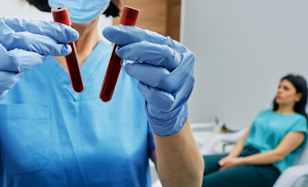 Medical professional holding blood vials for private blood testing at Hodgson Pharmacy.